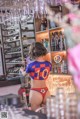 A woman in a bikini standing behind a bar.