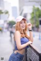 A woman in a pink hat and blue top posing for a picture.