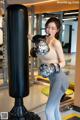 A woman in a boxing ring with a punching bag.