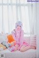 A woman sitting on a bed with stuffed animals.