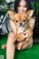 A woman holding a small dog in her arms.