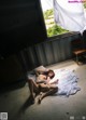 A woman laying on a bed in front of a window.