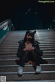 A woman wearing a cat mask sitting on a set of stairs.