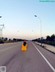 A woman riding a scooter down the middle of a road.