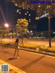 A naked woman standing in the middle of a street at night.