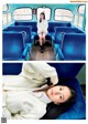 A woman sitting on a blue bus with her legs crossed.