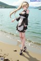 A woman in a maid outfit standing on a beach.